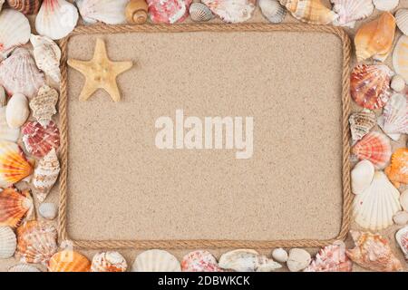 Schönen Rahmen aus Seil und Stern, Muscheln im Sand, die mit Platz für Ihr Bild, Text. Ansicht von oben. Stockfoto