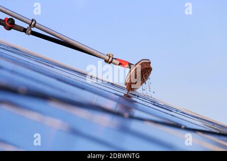 Reinigung von Solarzellen mit Pinsel und Wasser Stockfoto