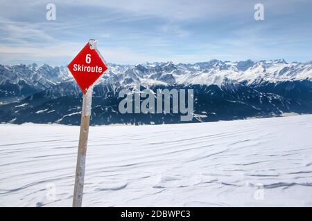 Red Ski route 6 Zeichen auf Neuschnee mit österreichischen Alpen und Himmel im Hintergrund, im Nordpark, Innsbruck fotografiert. Stockfoto