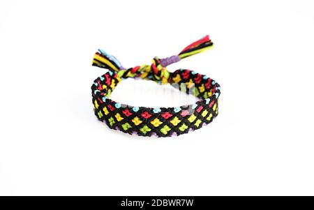 Selektive Fokus von gewebten DIY Freundschaft Armband handgemachte Stickerei hellen Faden mit Knoten auf weißem Hintergrund isoliert. boho Stockfoto