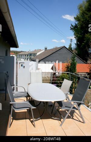 Eine Terrasse mit Edelstahlgeländern und beigefarbenen Bodenfliesen Stockfoto