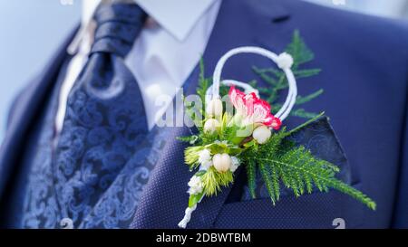 Bräutigam trägt Wedding Boutonniere auf blauem Anzug - Knopfloch Stockfoto