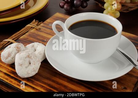 Schwarzer Kaffee mit Puderzucker-Kuchen-Donuts Stockfoto