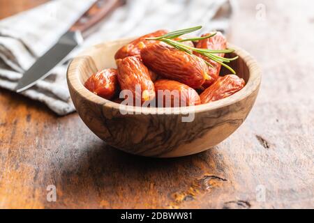 Mini Salami Würste in Schüssel auf Holztisch. Stockfoto