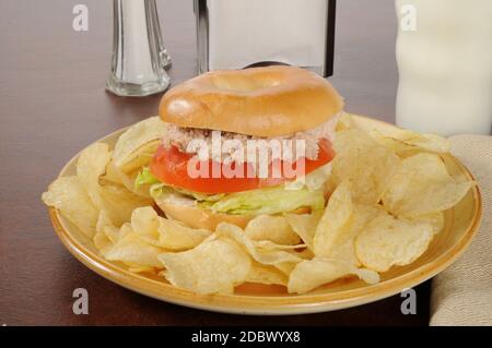 Ein Thunfisch-Sandwich auf einem Bagel mit Kartoffelchips Stockfoto