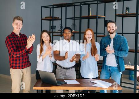 Portrait einer Gruppe von multiethnischen Geschäftsleuten, die applaudieren und dankbar sind Blick in die Kamera Stockfoto