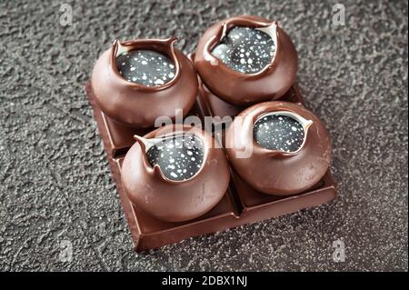 Handgefertigte Schokoladen-Bonbons auf schwarzem Hintergrund Stockfoto
