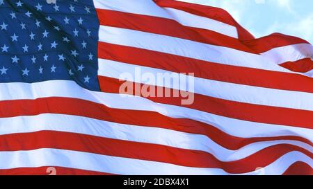 Amerikanische Flagge der USA flattert im Wind gegen einen klaren blauen Himmel an einem sonnigen Tag. Nahaufnahme. Stockfoto