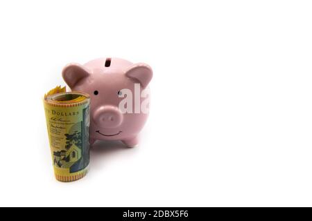 Rosa Sparschwein mit goldener Krone und Stapel von australischen 50-Dollar-Banknoten vor isoliert auf weißem Hintergrund mit Kopieplatz, ist Bargeld König c Stockfoto
