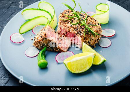 Gebackenes Thunfischsteak mit Gemüsegarnierung.Fisch mit Gemüse gekocht. Stockfoto