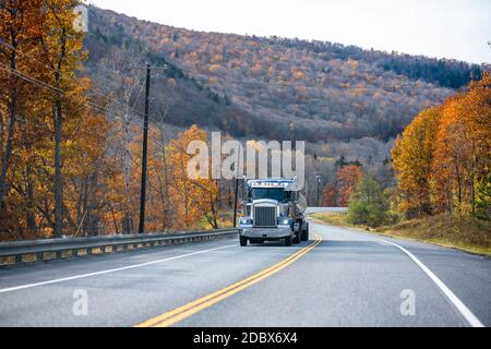Klassische blaue Tag Cab Industriequalität professionelle große Rig semi LKW Transport von Kraftstoff im Tank Sattelauflieger bergauf Die kurvenreiche Straße in au Stockfoto
