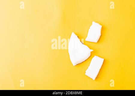 Happy Coconuts Tageskonzept, frische Kokosnuss Gruppe Stücke Scheiben, Studio Shot isoliert auf gelbem Hintergrund Stockfoto