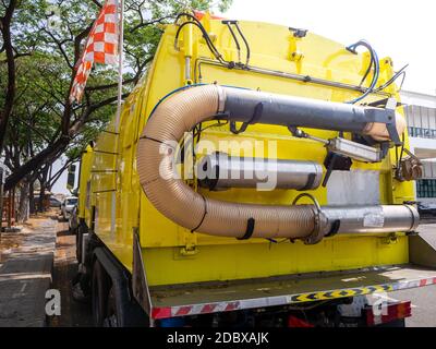 Ein Auto für die Reinigung von Straßen mit runden Bürsten auf einer Stadtstraße. Stockfoto