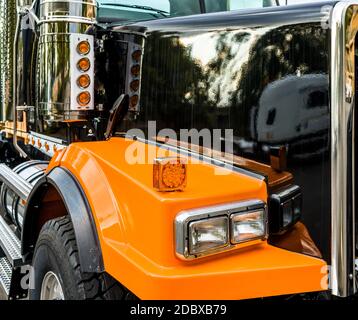 Vorderteil des gewerblichen Güterverkehrs stilvolle schwarz und orange Große Rig Sattelschlepper mit Chrom Zubehör und Glas Scheinwerfer und RE Stockfoto