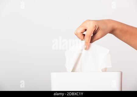 Junge Frau Grippe sie mit Hand, die weißes Gesichtstuch aus einer weißen Box für sauberes Taschentuch herausziehen, Studio auf weißem Hintergrund isoliert Stockfoto