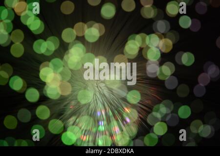 Ein Bokeh-fokussiertes Bild von einigen Glasfaserkabeln, durch die Lichter leuchten. Stockfoto