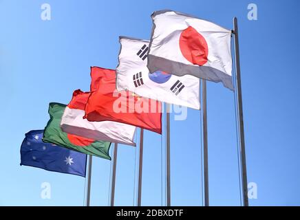 6 Flaggen Asiens und Ozeaniens, die im Wind fliegen: Japan, Südkorea, China, Indonesien, Bangladesch und Australien am Himmel Stockfoto