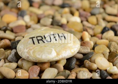Ein Stein, auf dem das Wort Wahrheit zu Bestätigungszwecken eingraviert ist. Stockfoto