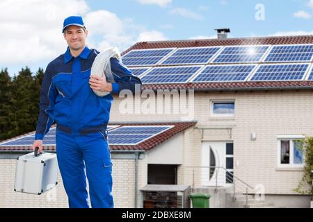 Lächelnder Elektriker-Reparaturtechniker Vor Dem Haus Stockfoto