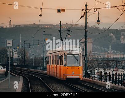 Eine alte gelbe Straßenbahn am Donauufer. Budapest im Winter Stockfoto