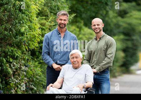 Alter Behinderter Großvater Im Rollstuhl Mit Fürsorglicher Familie Stockfoto