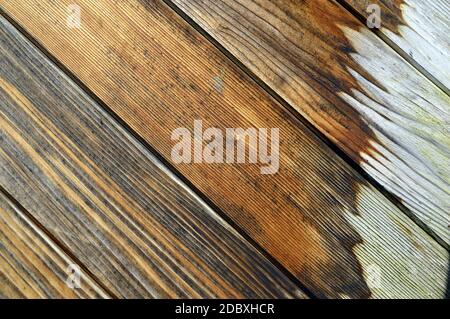 Holzwand aus diagonalen Brettern mit weiß bemalten Flecken. Hintergrund Stockfoto