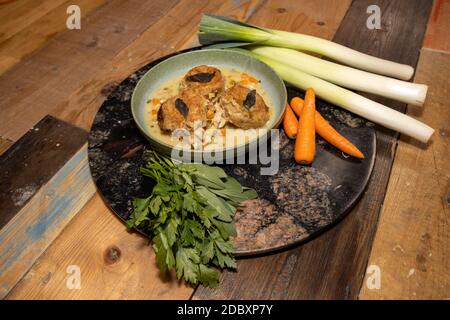 Ein köstlicher Hühnchen-Kobolder mit Knödeln in einer Holzküche Arbeitsplatte umgeben von Gemüse Stockfoto