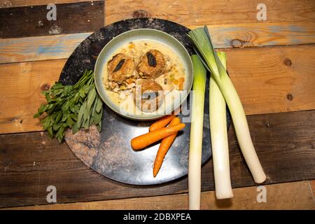 Ein köstlicher Hühnchen-Kobolder mit Knödeln in einer Holzküche Arbeitsplatte umgeben von Gemüse Stockfoto