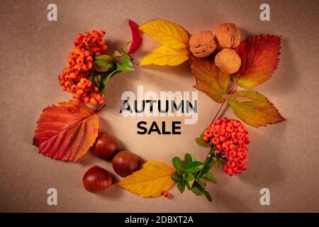 Autumn Sale Banner mit einem Kranz aus Kastanien, Nüssen und Herbstblättern, ein flaches Lay, von oben auf einem braunen Hintergrund geschossen Stockfoto