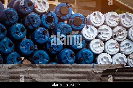 Selektiver Fokus auf leere alte Chemiefässer. Blaue und weiße Ölfass. Kunststofföltank. Lager für giftige Abfälle. Gefährliche Chemikalienfass. Industrielle Wa Stockfoto