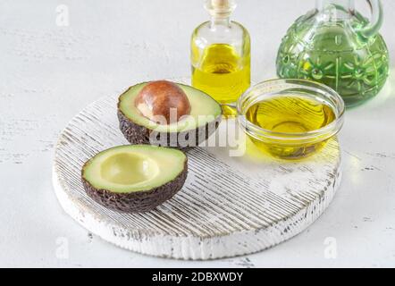 Frische Avocado mit Avocado-Öl auf dem Holzbrett Stockfoto