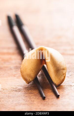 Chinesische Glücksplätzchen. Glücksplätzchen auf Essstäbchen auf Holztisch. Stockfoto