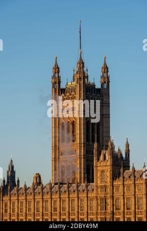 Rauch oder Dampf steigt aus dem Palace of Westminster, Houses of Parliament, an einem hellen, sonnigen, aber kalten Novembertag in London, Großbritannien. Victoria Tower