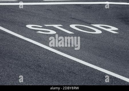 Stop Wort über eine asphaltierte Straße Stockfoto