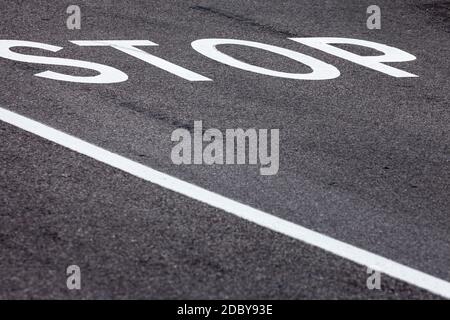 Stop Wort über eine asphaltierte Straße Stockfoto