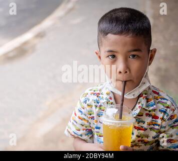 Junge, der Wasser aus einem Glas Wasser saugt Stockfoto