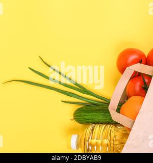 Papiertüte mit Lebensmitteln für die Zeit der Quarantäne Isolation auf gelbem Hintergrund. Lieferung, Spende, Coronavirus, Copyspace. Stockfoto