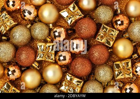 Weihnachtsspielzeug auf goldenem, glitzerndem Hintergrund. Festliche, monochrome Textur. Stockfoto