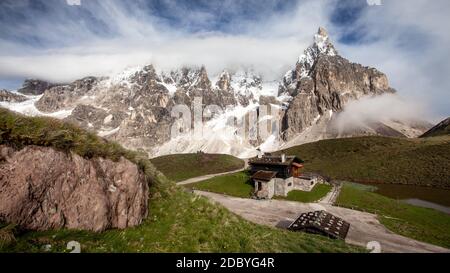 Cimon della Pala (auch genannt "Das Matterhorn der Dolomiten") mit schneebedeckten Gipfeln an einem sonnigen Tag mit dramatischen Wolken über. San Martino di Cas Stockfoto