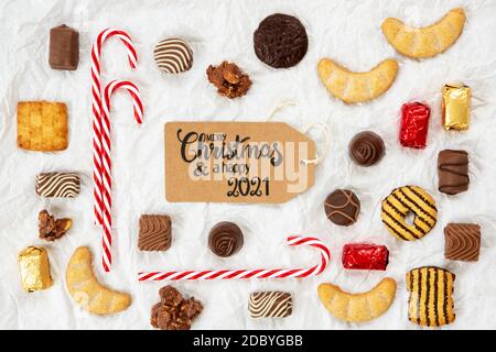 Ein braunes Label mit englischer Kalligraphie Frohe Weihnachten und EIN Happy 2021. Weihnachts-Candy-Kollektion Mit Hausgemachten Cookies. Stockfoto