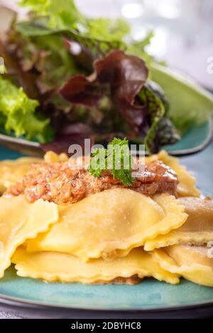 Ravioli mit Sahnesauce und Salat Stockfoto