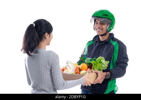 Lebensmittelgeschäft Lieferung. Fahrer Kurier mit Lebensmittel senden Online-Bestellung an weibliche Kunden isoliert über weiß Stockfoto