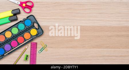 Schulbedarf auf einem hölzernen Hintergrund mit Kopierraum Stockfoto