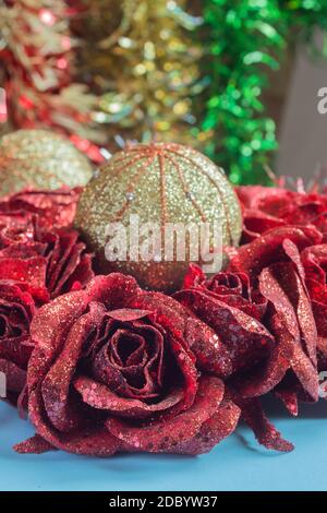 Verschiedene Weihnachtsschmuck auf einem Tisch. Blumen, Rosen, Weihnachtskugeln und bunte Zinnchen. Stockfoto