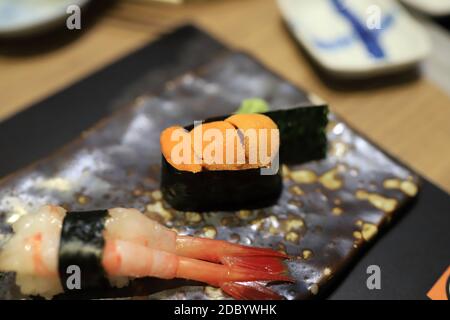 Seeigel-Sushi in Algen auf einem traditionellen japanischen Gericht in einem japanischen Restaurant eingewickelt. Selektiver Fokus. Stockfoto