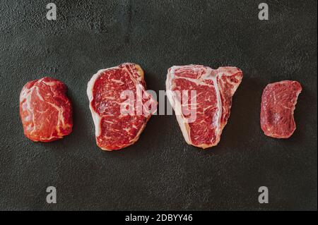 Verschiedene Rindersteaks auf dunklem Hintergrund Stockfoto