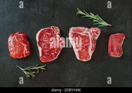 Verschiedene Rindersteaks auf dunklem Hintergrund Stockfoto