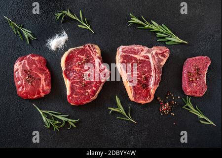 Verschiedene Rindersteaks auf dunklem Hintergrund Stockfoto