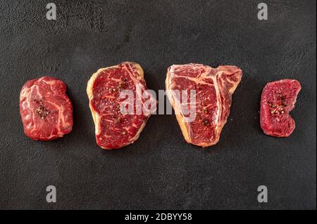 Verschiedene Rindersteaks auf dunklem Hintergrund Stockfoto