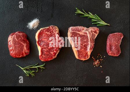 Verschiedene Rindersteaks auf dunklem Hintergrund Stockfoto